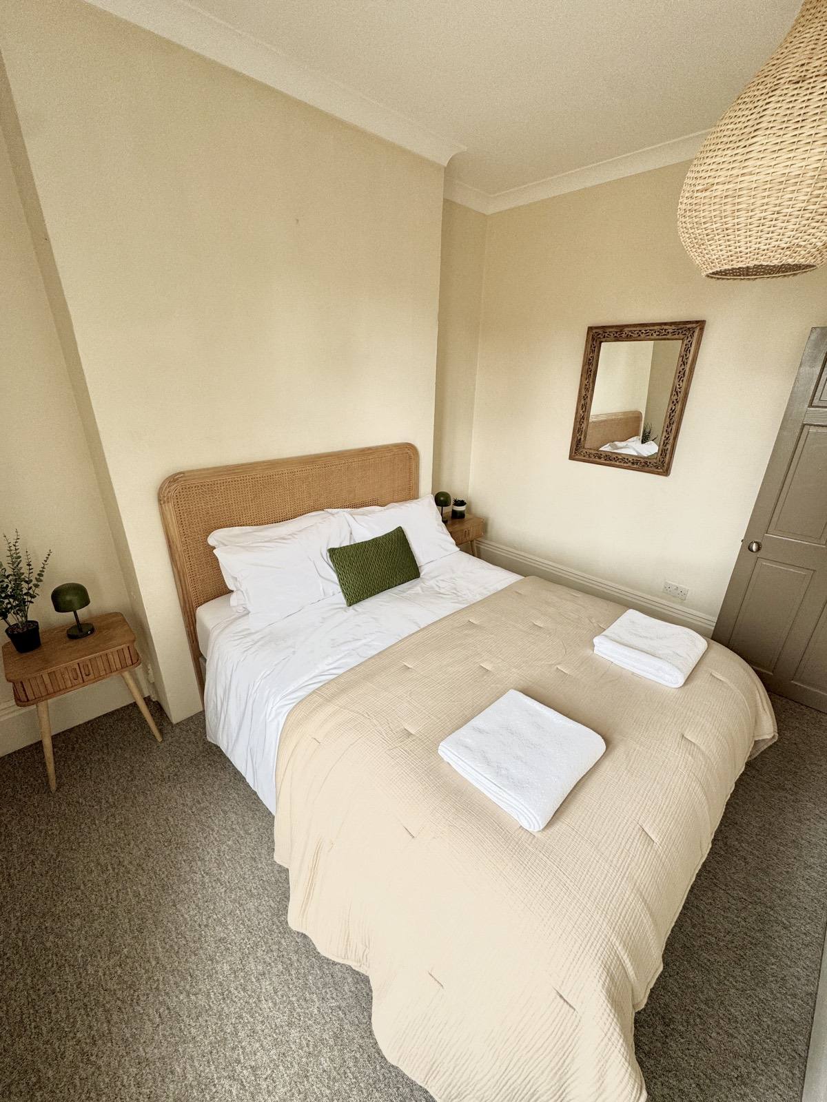 Restful double bedroom with bedside table and mirror