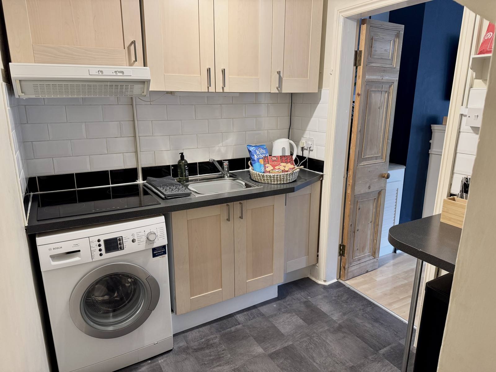 Compact kitchen area with microwave and under-counter fridge