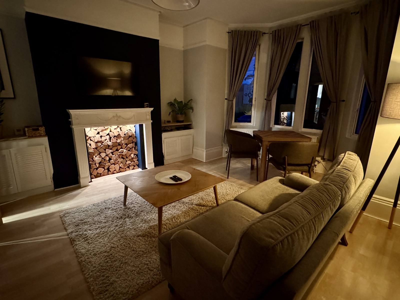 Cosy living room in the evening with the feature fireplace and warm lamplight