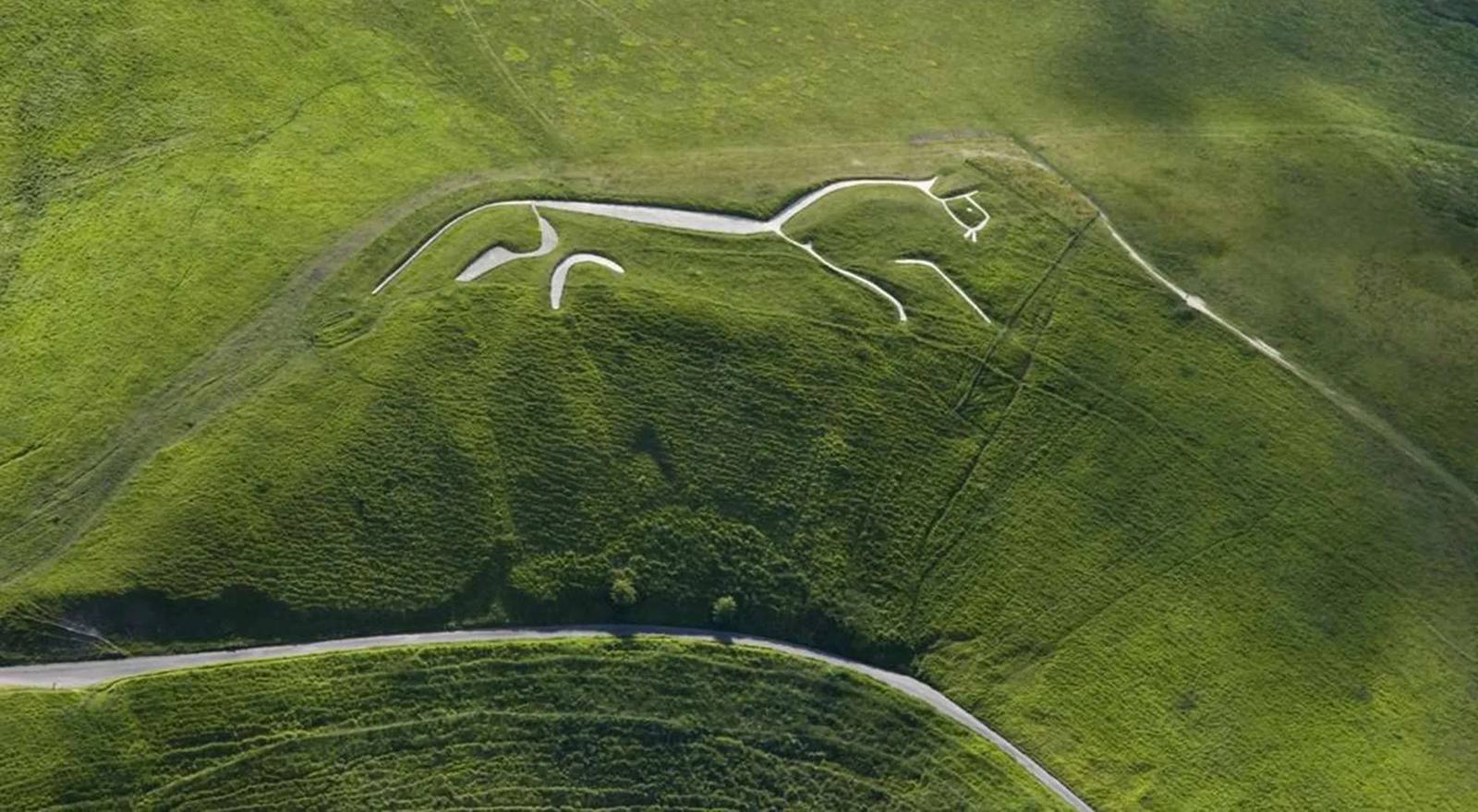 The Uffington White Horse, an ancient chalk hill figure cut into the green downs